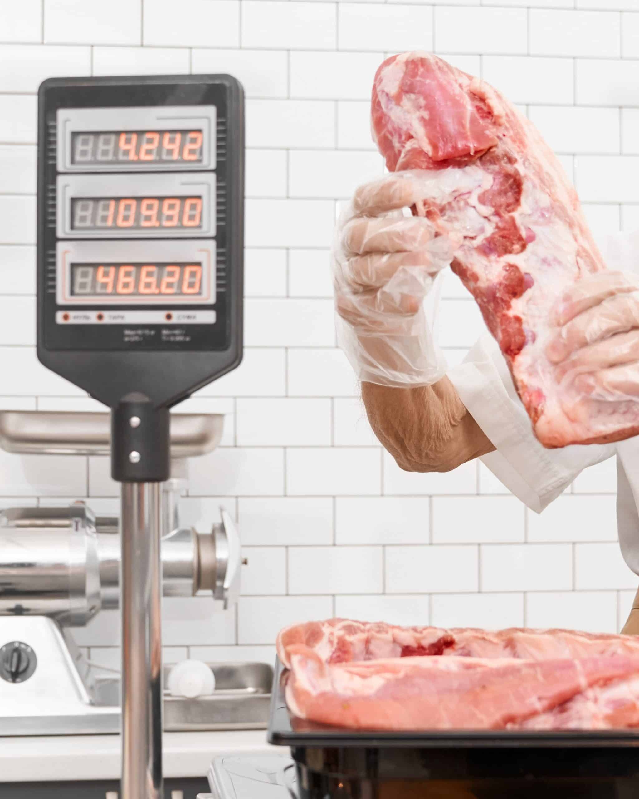 incognito-male-butcher-demonstrating-meat-2023-11-27-05-04-33-utc